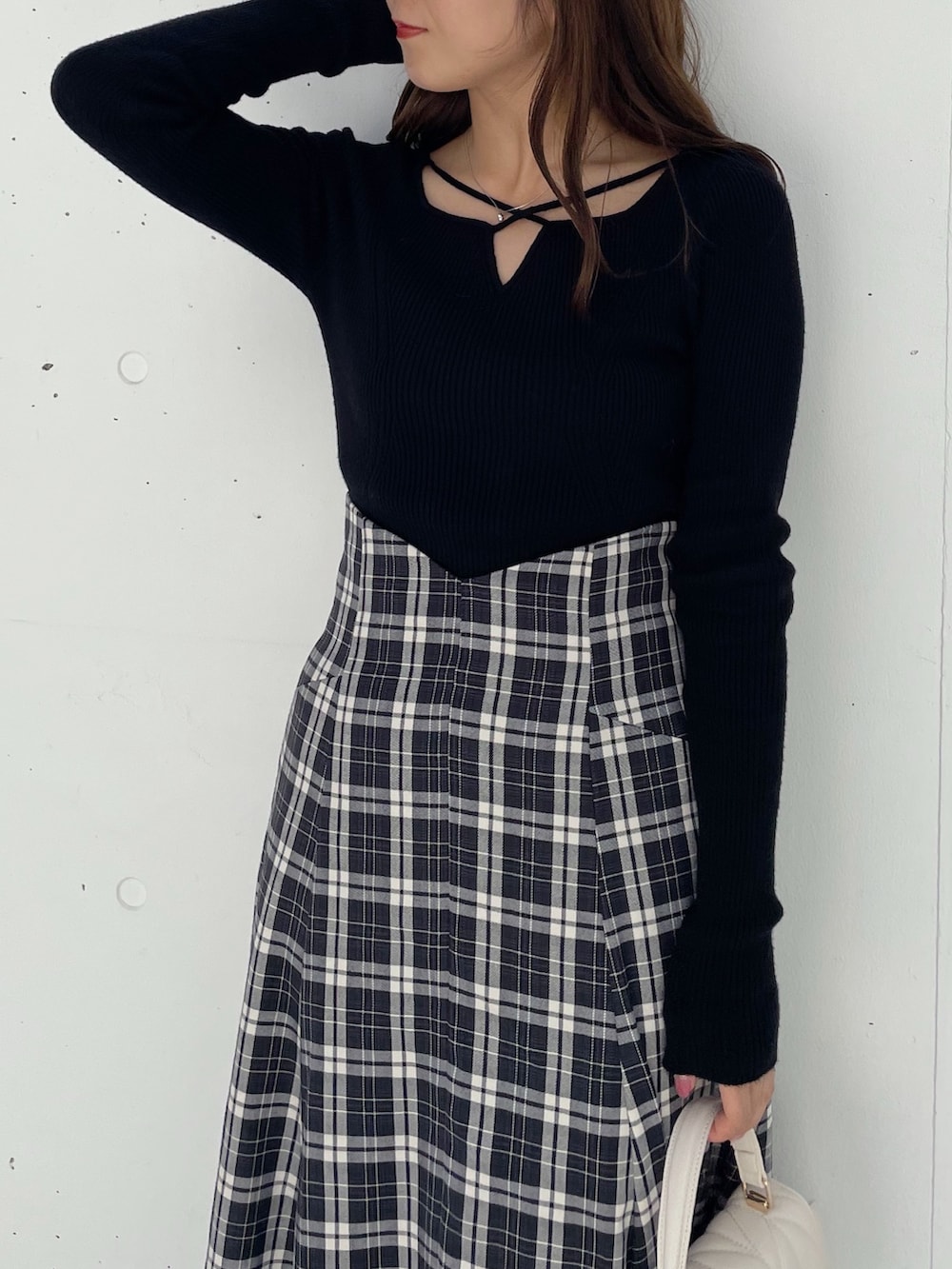 ブラック系のスカート、ブラック系のブーツ、ブラック系のニット/セーターを着用したレディースの秋コーディネートの2枚目の写真