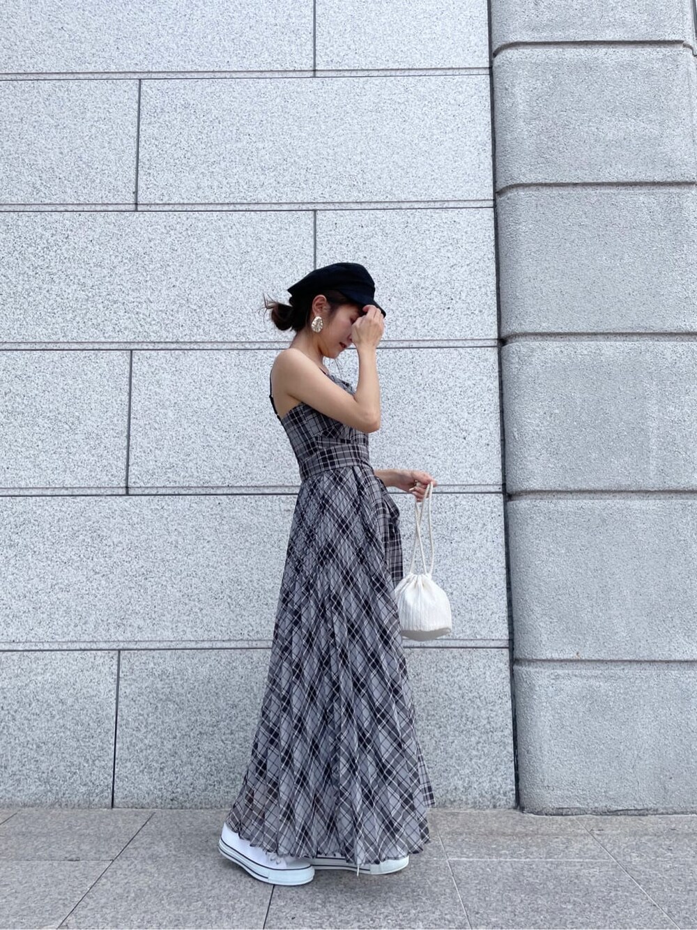 ブラック系のワンピース、ホワイト系のスニーカー、ブラック系のキャスケットを着用したレディースの夏コーディネートの6枚目の写真