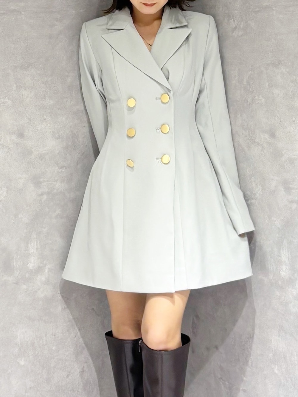 グリーン系のワンピース、ブラウン系のブーツを着用したレディースの冬コーディネートの4枚目の写真