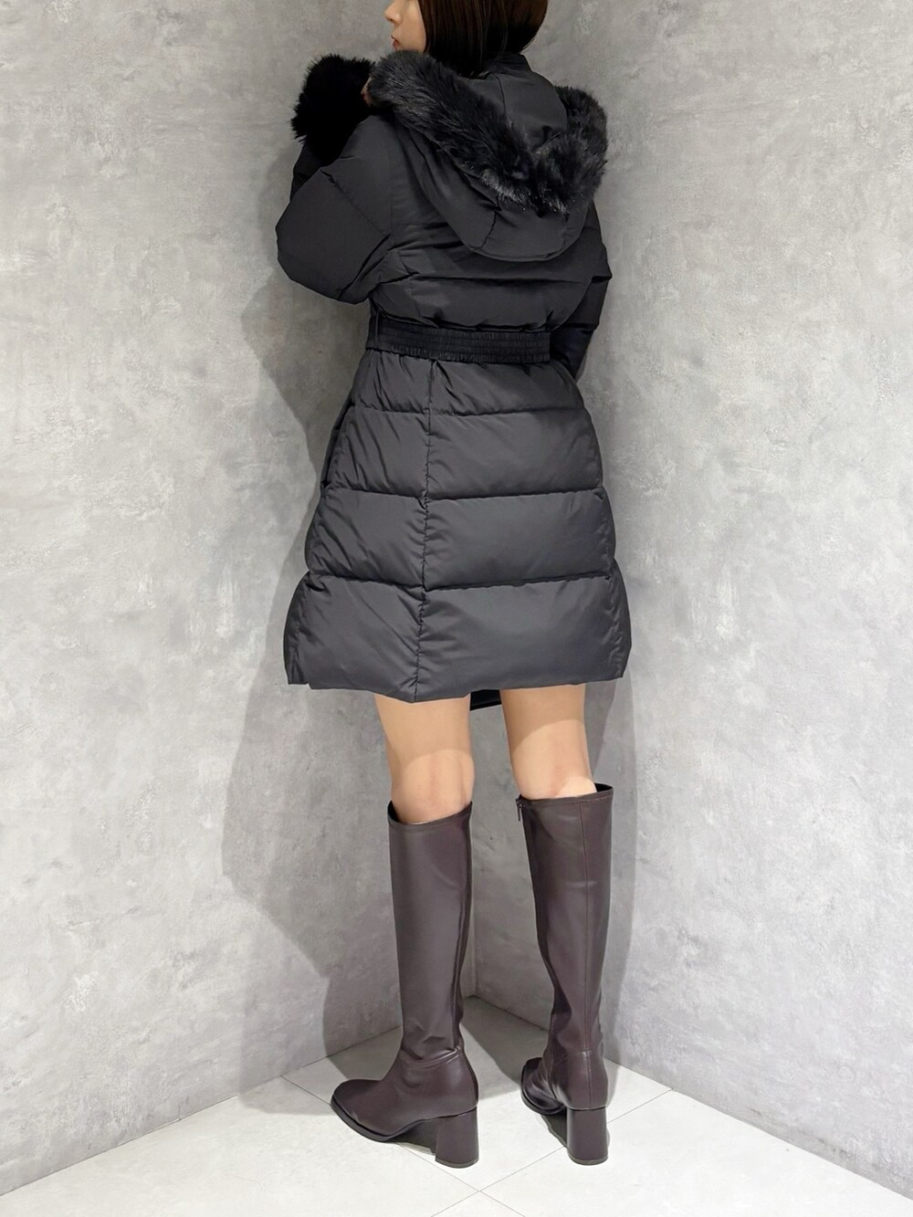 ブラウン系のブーツ、ブラック系のハンドバッグ、ブラック系のニット/セーターを着用したレディースの秋コーディネートの4枚目の写真