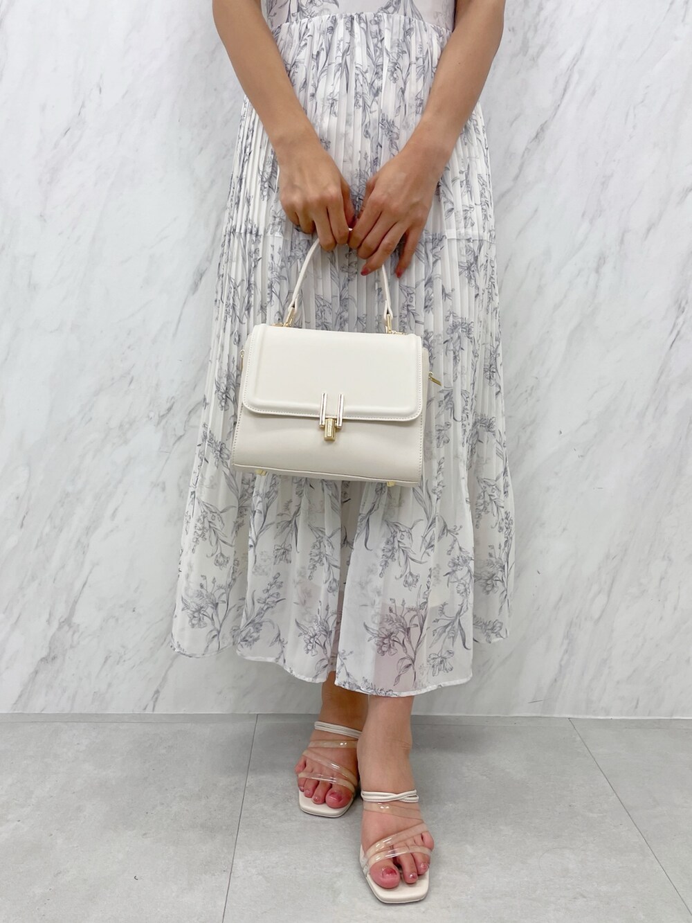 ホワイト系のワンピース、その他のサンダル、ホワイト系のショルダーバッグを着用したレディースの夏コーディネートの2枚目の写真