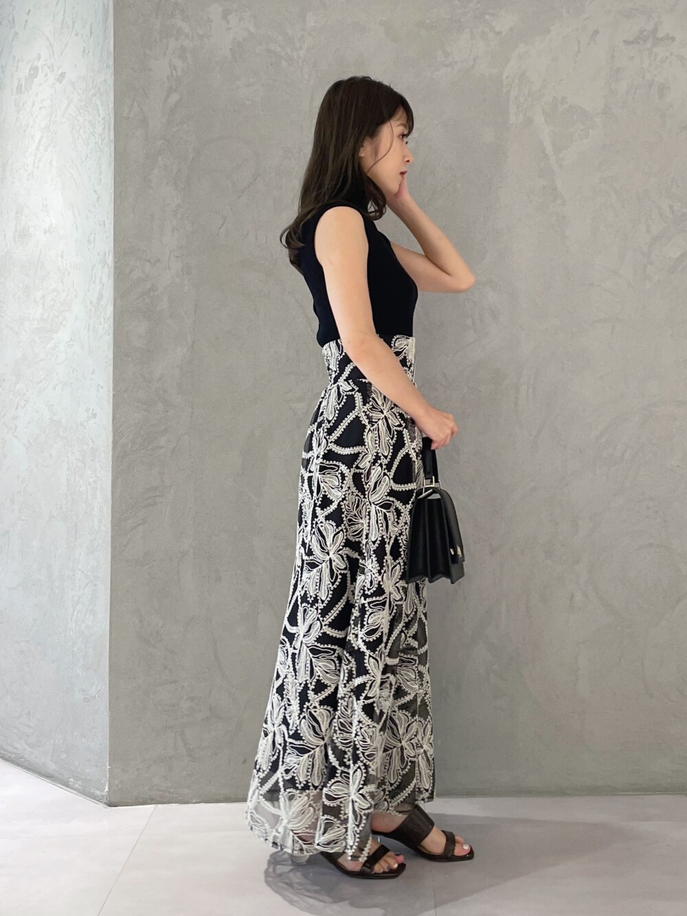 ブラウン系のサンダル、ブラック系のハンドバッグ、ブラック系のニット/セーターを着用したレディースの夏コーディネートの5枚目の写真