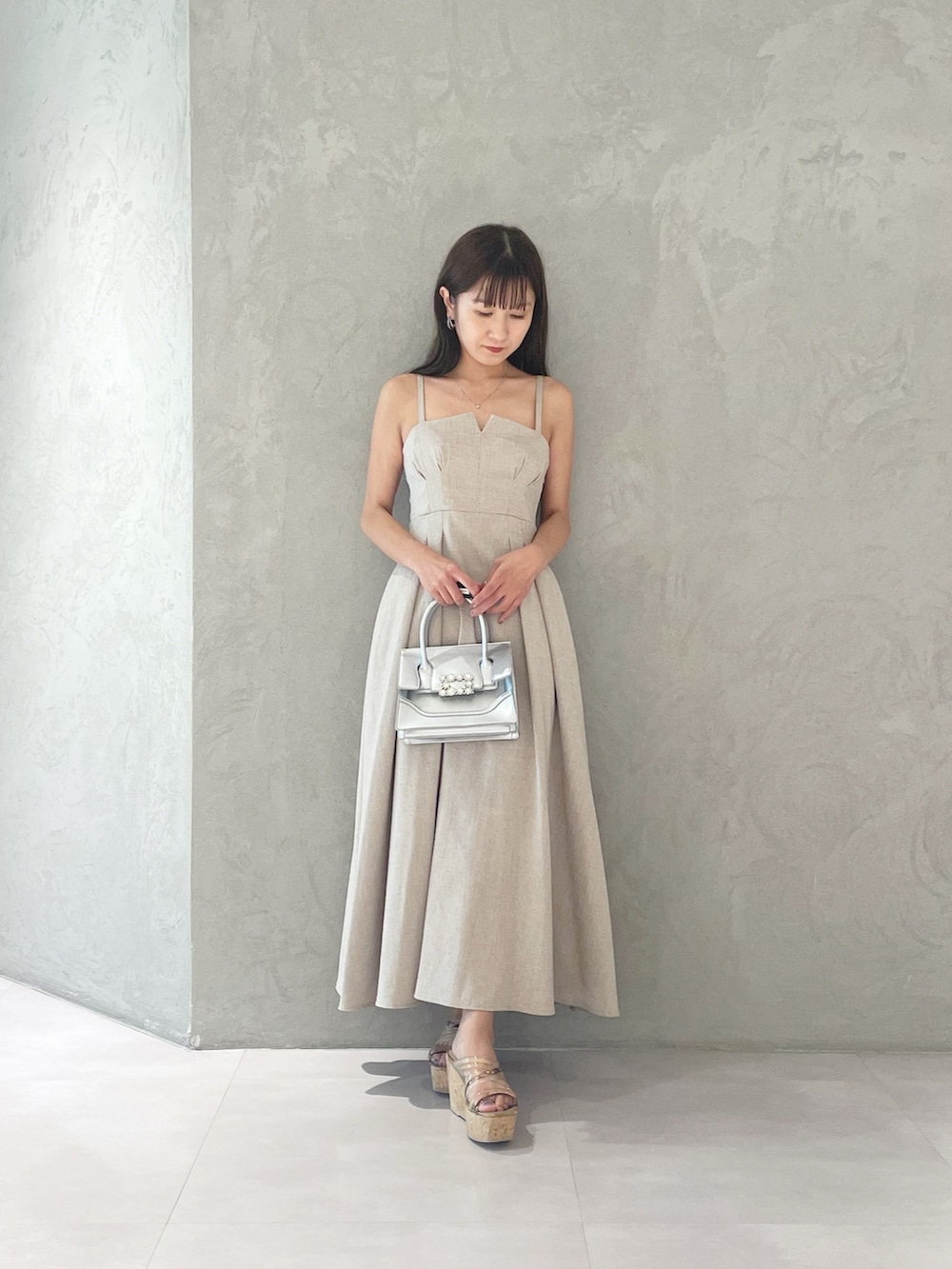 ベージュ系のワンピース、シルバー系のショルダーバッグ、ブラウン系のサンダルを着用したレディースの夏コーディネートの6枚目の写真