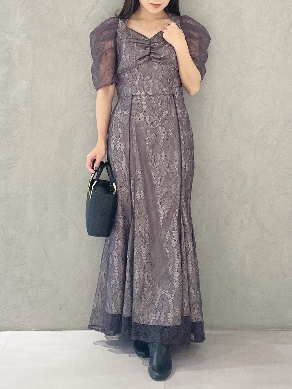 パープル系のシャツ/ブラウス、ブラック系のハンドバッグ、ブラック系のブーツを着用したレディースの冬コーディネートの6枚目の写真