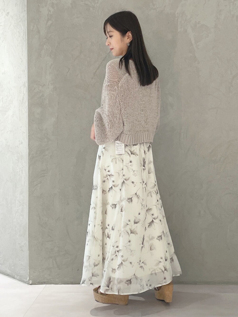 ベージュ系のワンピース、ブラウン系のサンダル、ベージュ系のカーディガン/ボレロを着用したレディースの春コーディネートの3枚目の写真