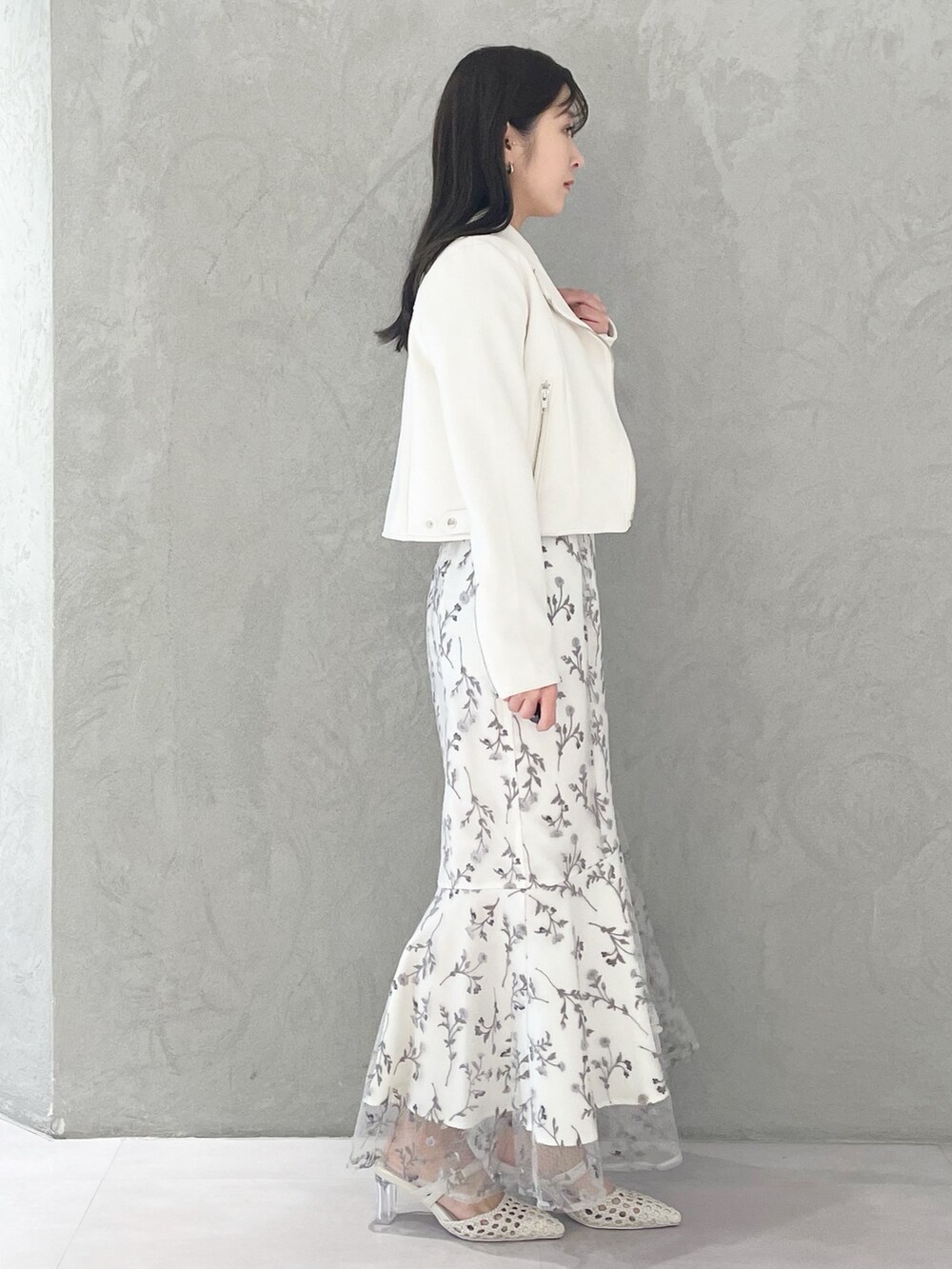 グレー系のワンピース、ホワイト系のパンプス、ホワイト系のライダースジャケットを着用したレディースの春コーディネートの3枚目の写真