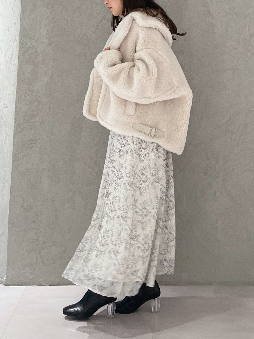 ホワイト系のワンピース、ホワイト系のその他アウター、ブラック系のブーツを着用したレディースの秋コーディネートの4枚目の写真