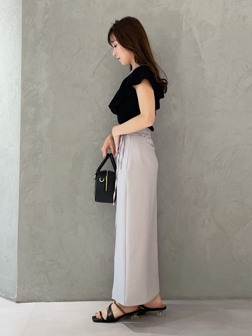 ブラック系のボストンバッグ、ブラック系のニット/セーター、ブラック系のサンダルを着用したレディースの春コーディネートの7枚目の写真