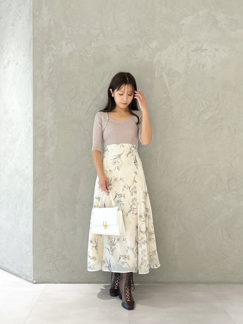 ベージュ系のワンピース、ブラウン系のブーツ、ホワイト系のショルダーバッグを着用したレディースの秋コーディネートの6枚目の写真