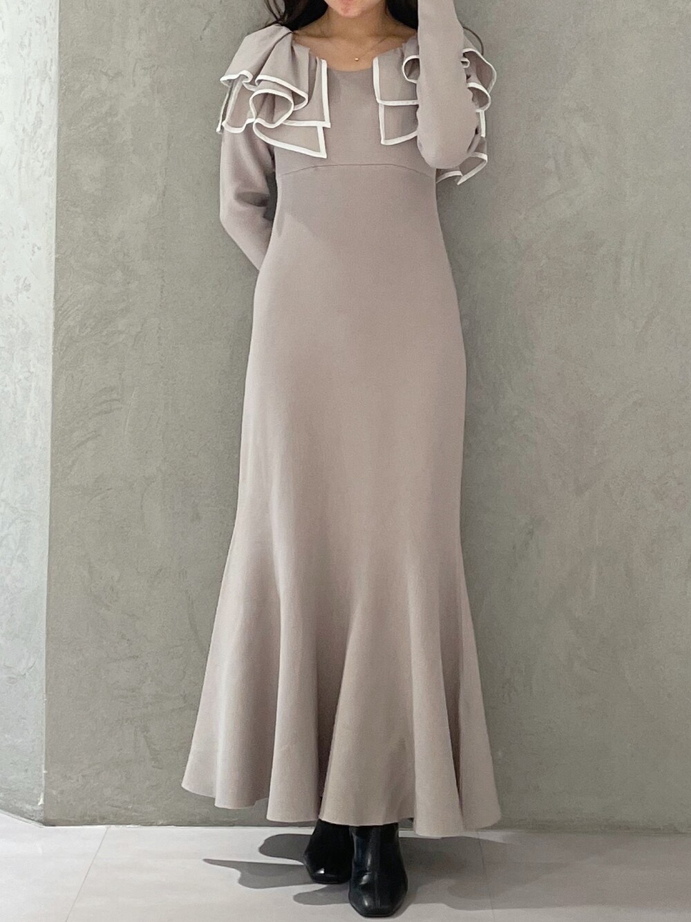 ベージュ系のワンピース、ホワイト系のチェスターコート、ブラック系のブーツを着用したレディースの冬コーディネートの4枚目の写真