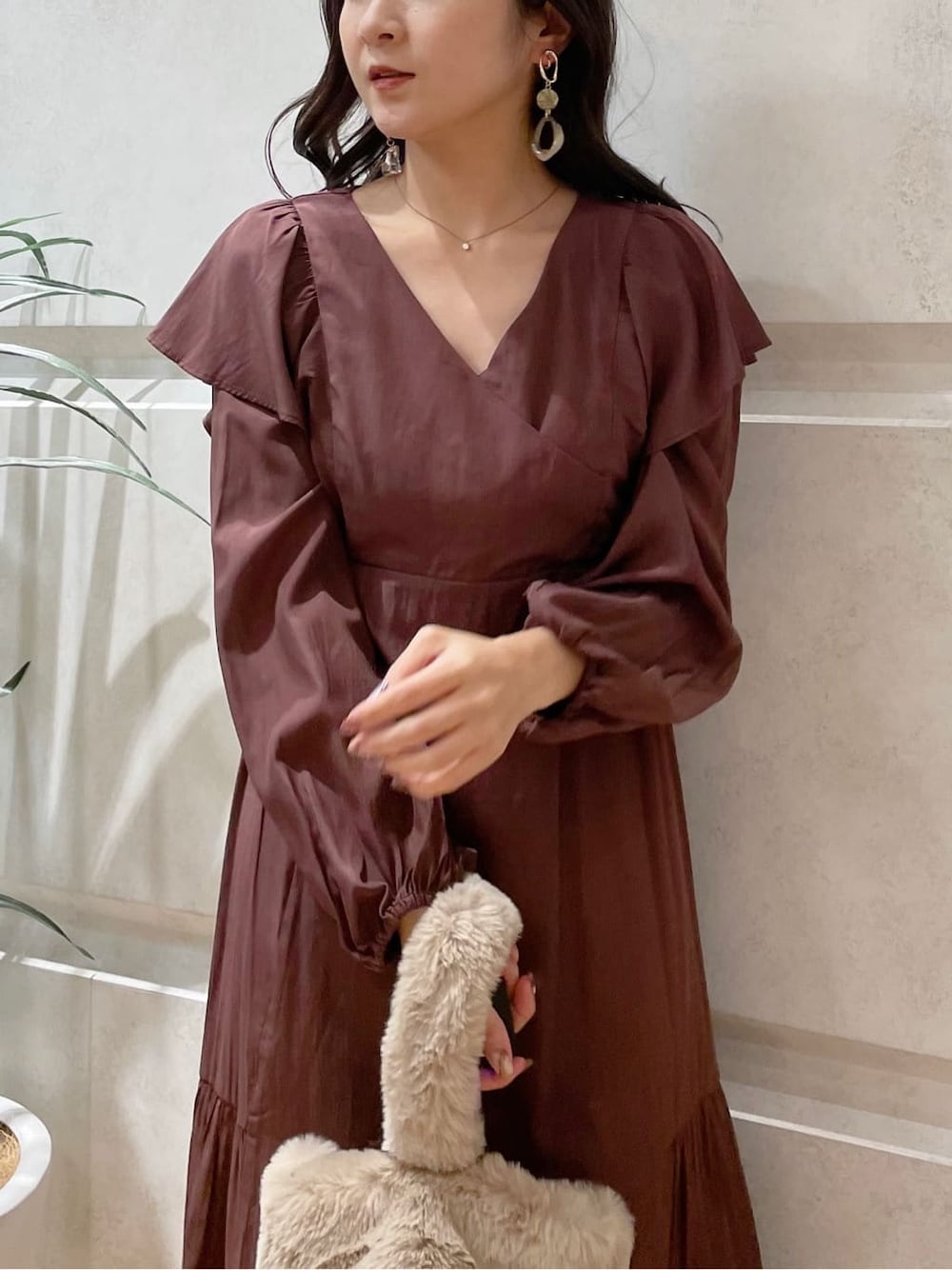 ホワイト系のその他アウター、ブラウン系のワンピース、ベージュ系のハンドバッグを着用したレディースの冬コーディネートの3枚目の写真