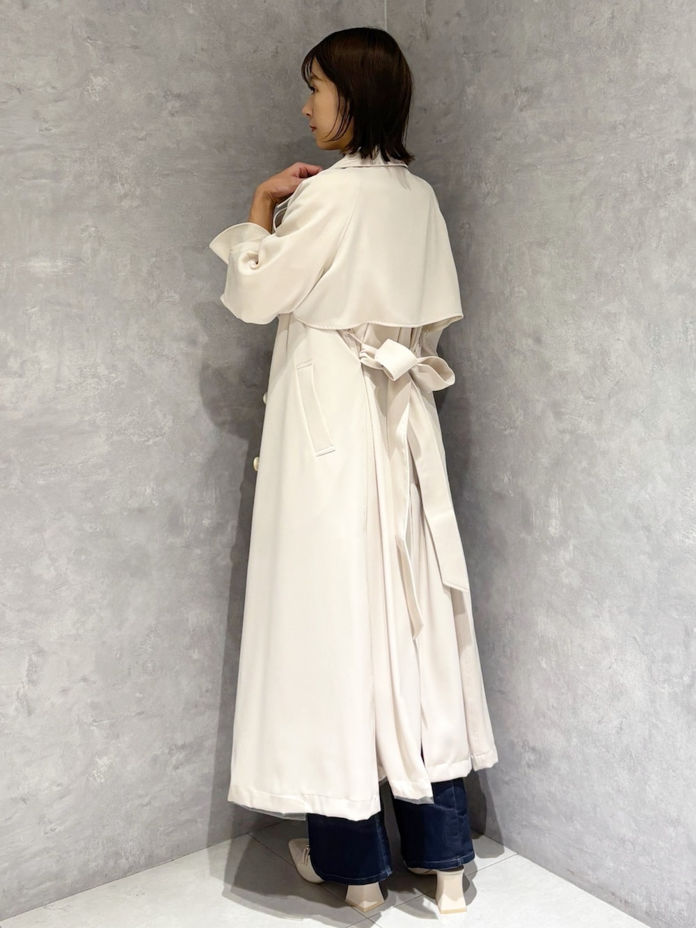 ブルー系のデニムパンツ、ホワイト系のパンプス、イエロー系のニット/セーターを着用したレディースの冬コーディネートの4枚目の写真