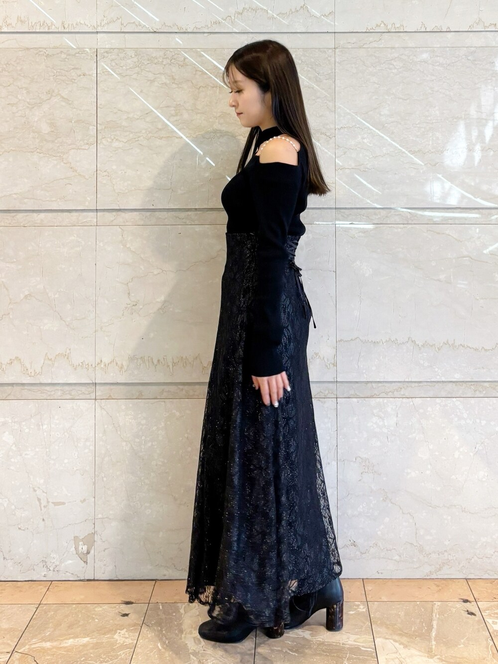 ブラック系のスカート、ブラック系のニット/セーター、ブラック系のブーツを着用したレディースの冬コーディネートの9枚目の写真