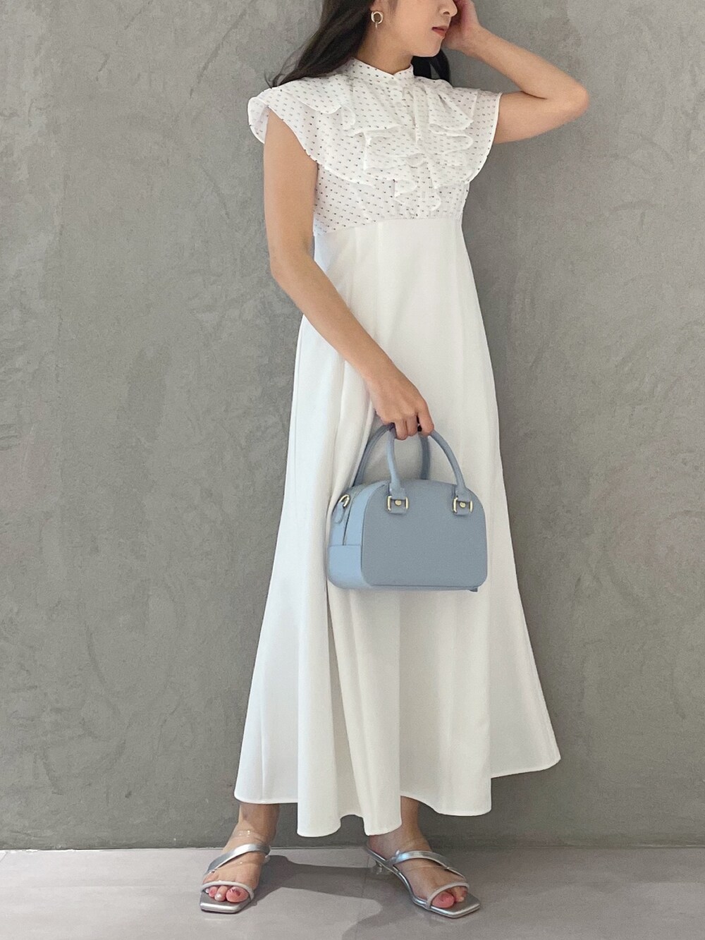 ブルー系のボストンバッグ、シルバー系のサンダル、その他のワンピースを着用したレディースの春コーディネートの2枚目の写真