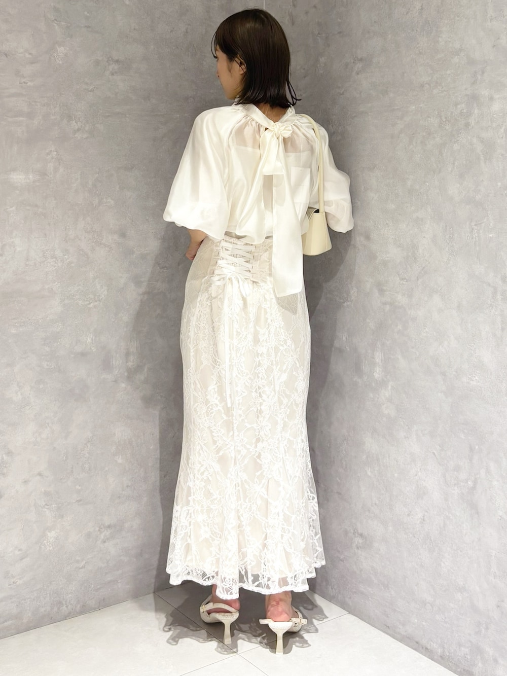 ホワイト系のスカート、ホワイト系のシャツ/ブラウス、ホワイト系のハンドバッグを着用したレディースの春コーディネートの3枚目の写真