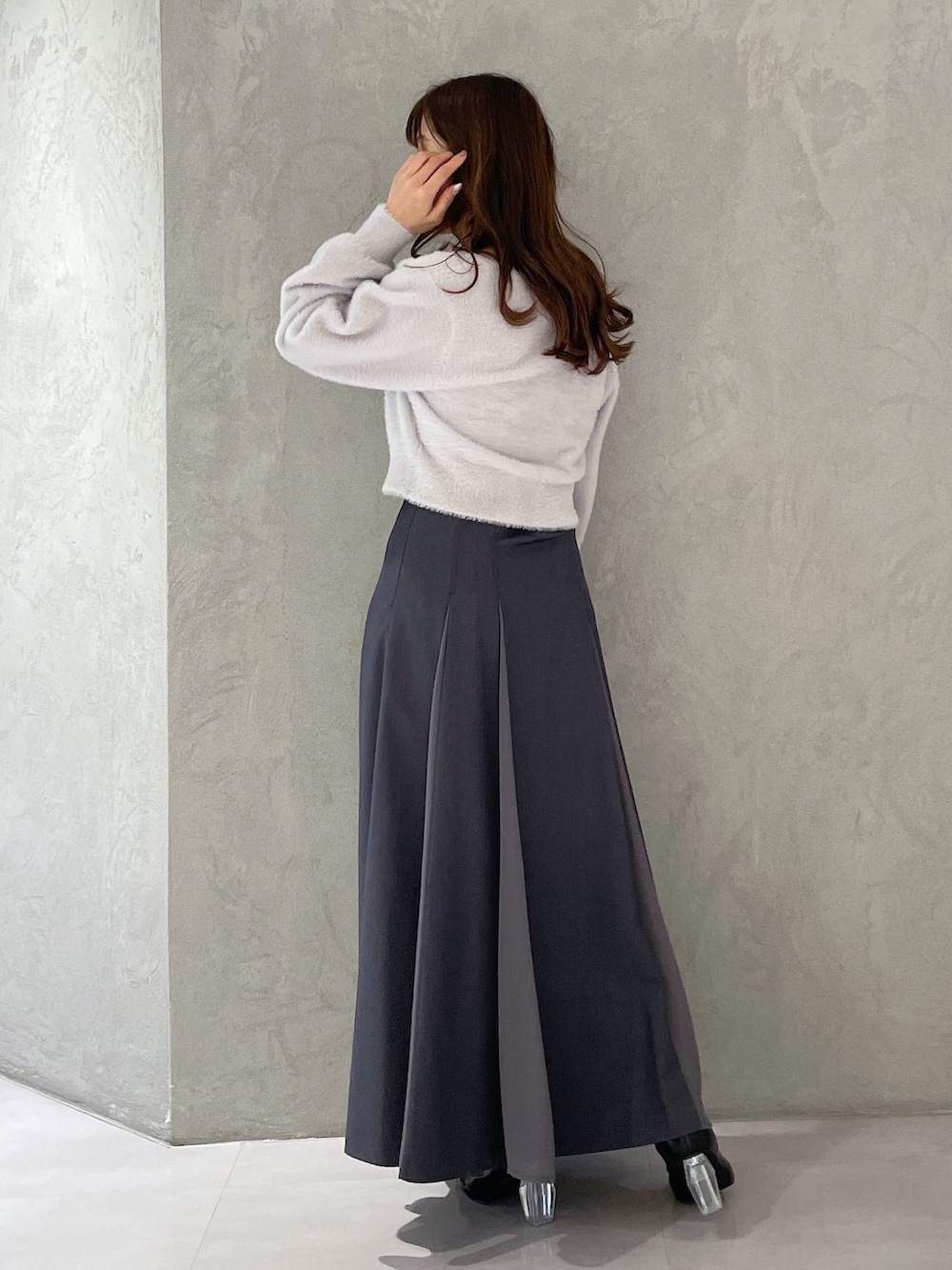 グレー系のカーディガン/ボレロ、グレー系のスカート、ブラック系のブーツを着用したレディースの冬コーディネートの3枚目の写真