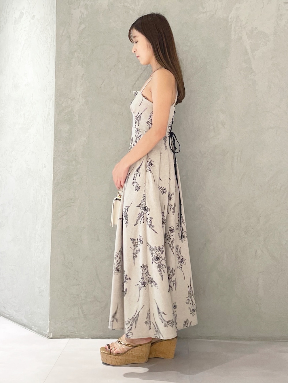 ベージュ系のワンピース、ブラウン系のサンダル、ホワイト系のハンドバッグを着用したレディースの夏コーディネートの6枚目の写真