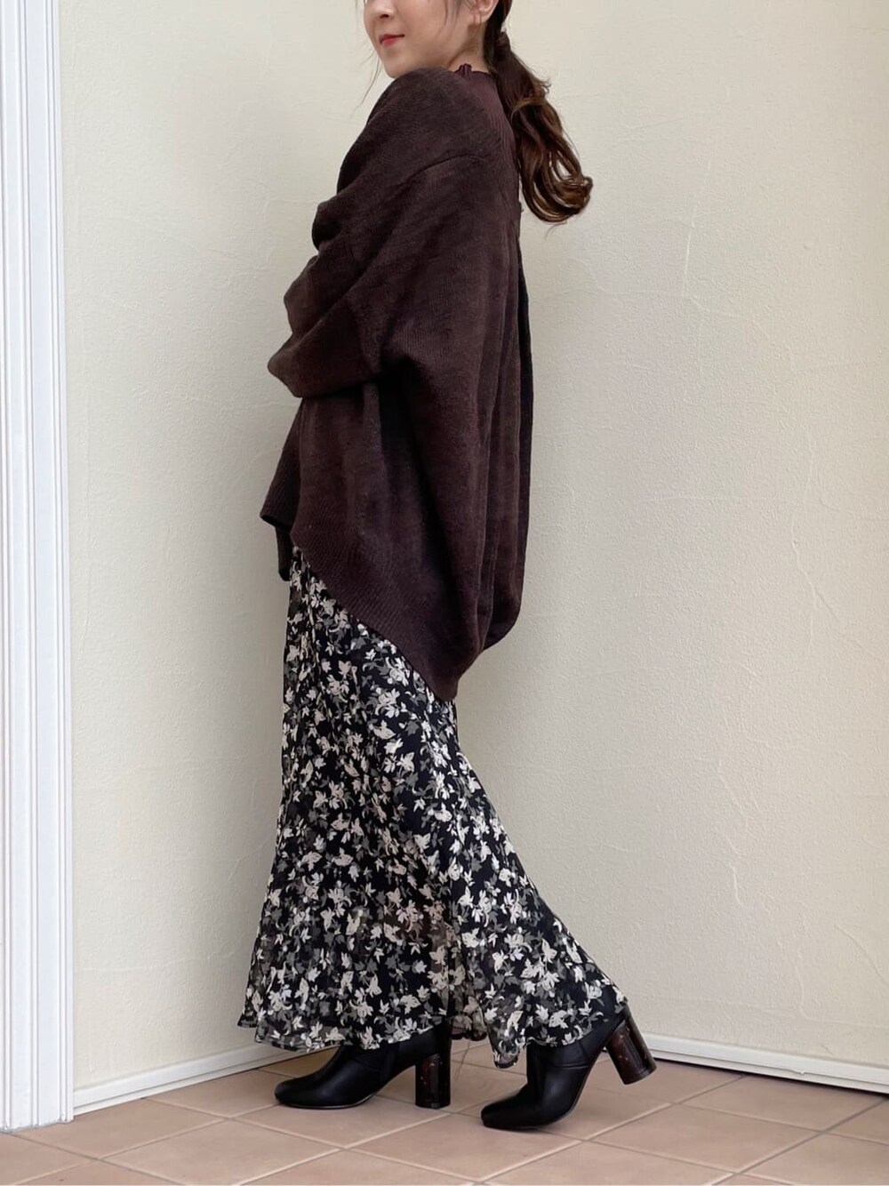 ブラック系のスカート、ブラウン系のニット/セーター、ブラック系のその他シューズを着用したレディースの秋コーディネートの5枚目の写真