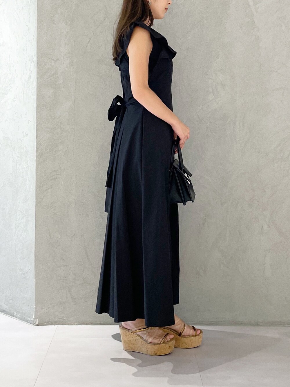 ブラック系のワンピース、ブラウン系のサンダル、ブラック系のショルダーバッグを着用したレディースの夏コーディネートの3枚目の写真