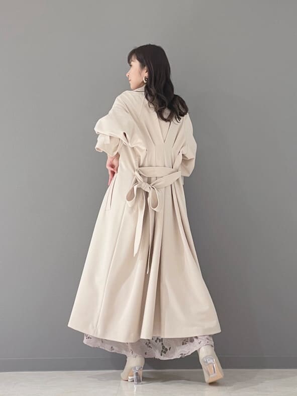 ベージュ系のその他シューズ、ベージュ系のトレンチコート、イエロー系のショルダーバッグを着用したレディースの冬コーディネートの9枚目の写真