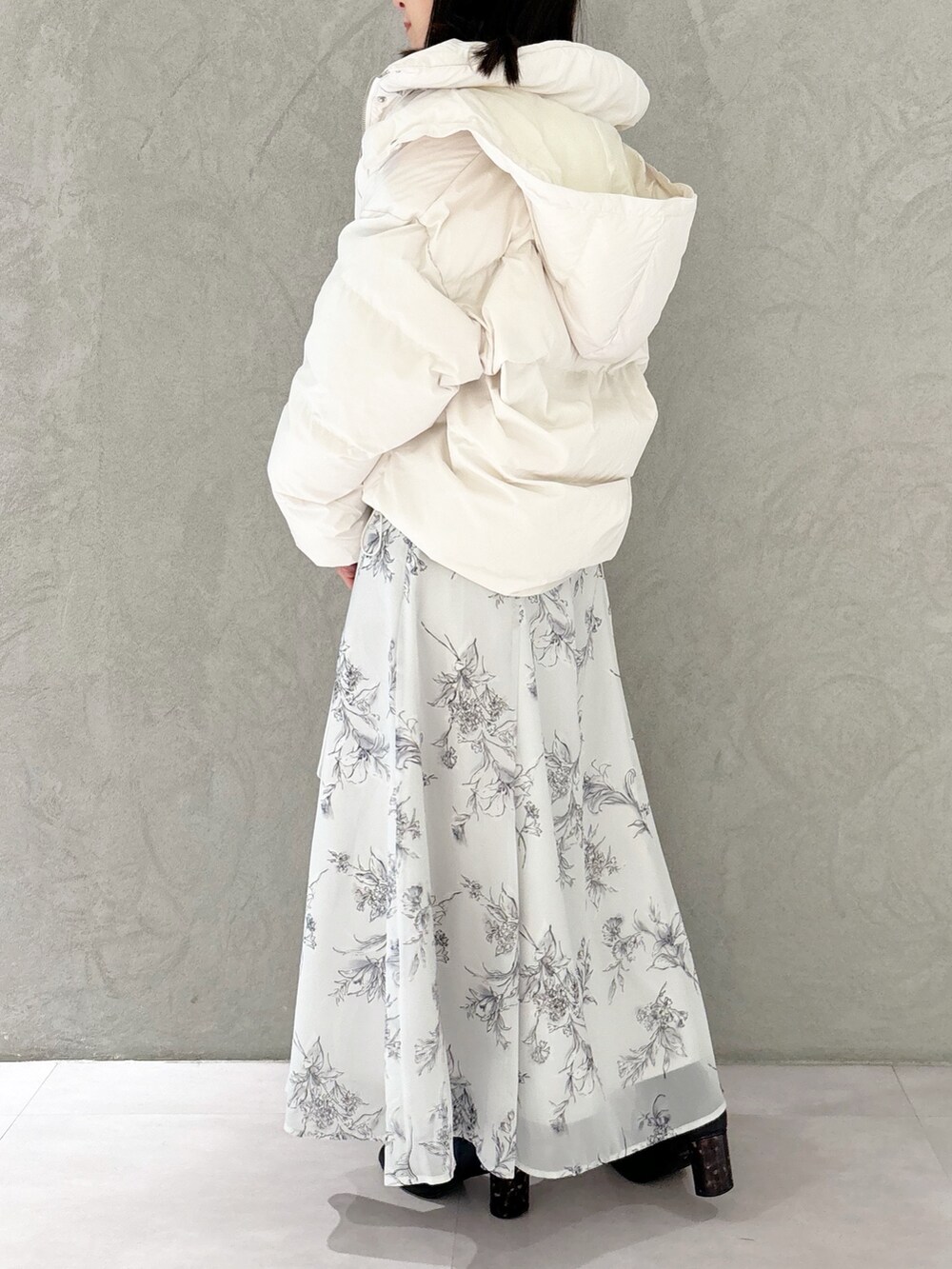 ブラック系のワンピース、ブラック系のブーツ、ホワイト系のハンドバッグを着用したレディースの秋コーディネートの7枚目の写真