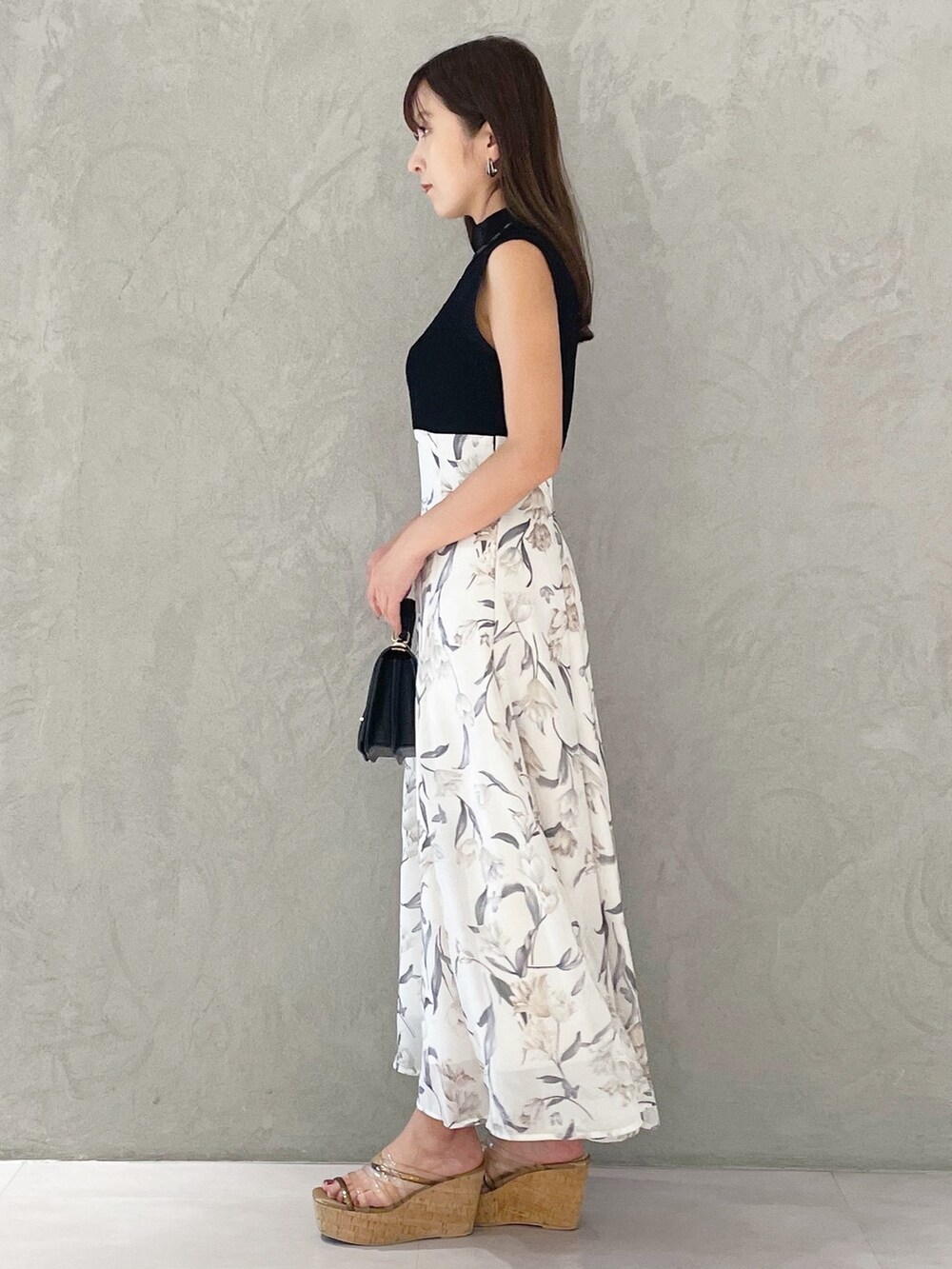 ブラック系のワンピース、ブラウン系のサンダル、ブラック系のハンドバッグを着用したレディースの夏コーディネートの4枚目の写真