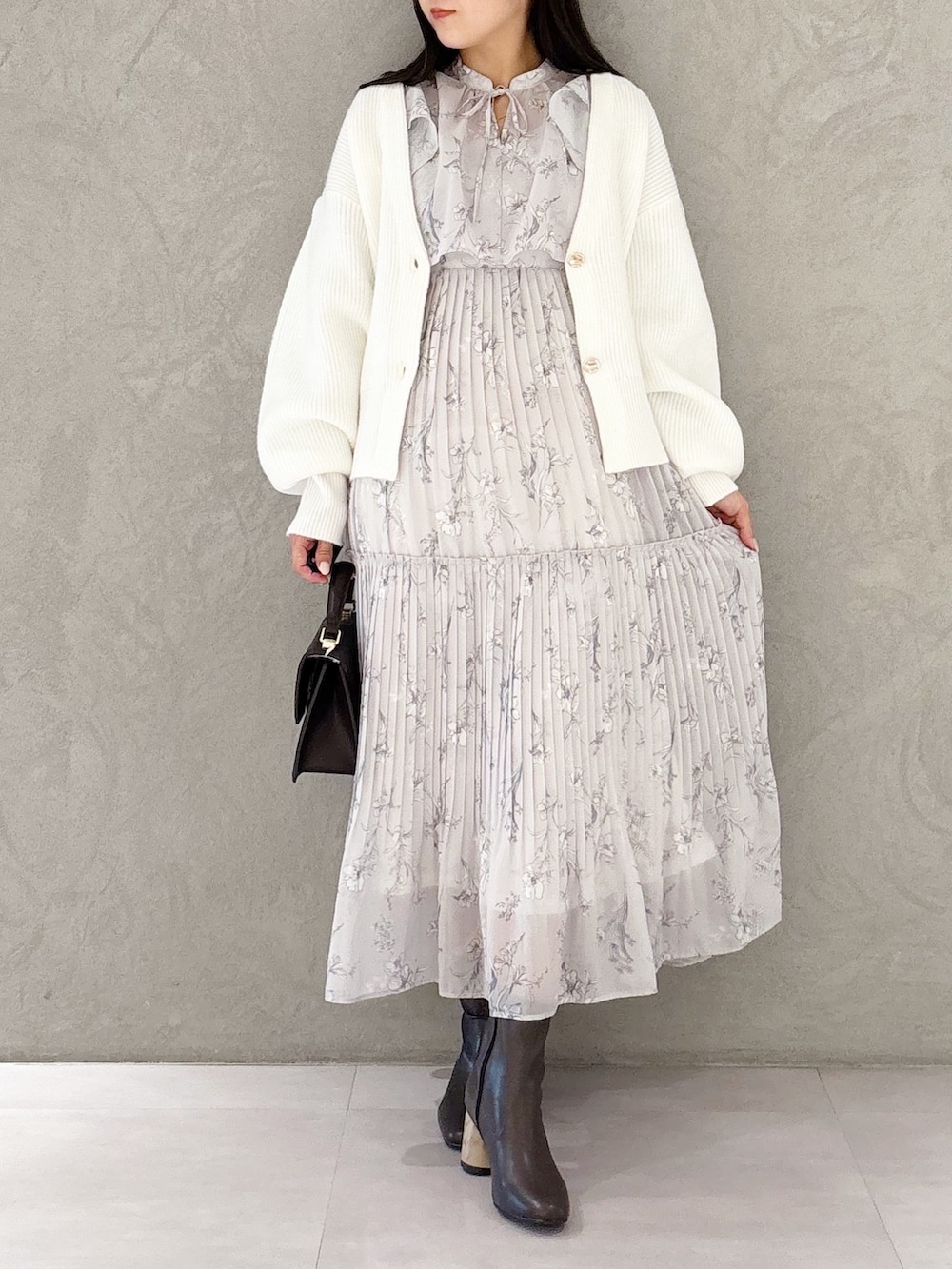 ピンク系のワンピース、ブラウン系のブーツ、ブラウン系のハンドバッグを着用したレディースの冬コーディネートの6枚目の写真