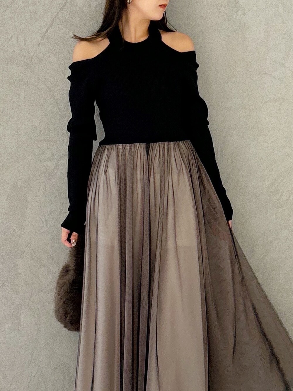 ブラック系のワンピース、ブラック系のブーツ、ブラウン系のハンドバッグを着用したレディースの秋コーディネートの7枚目の写真