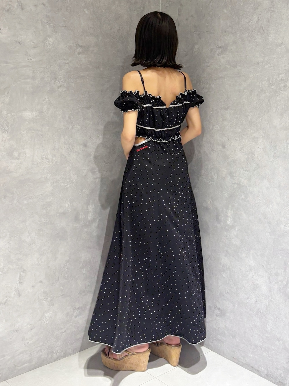 ブラック系のワンピース、ブラウン系のサンダル、ブラック系のショルダーバッグを着用したレディースの春コーディネートの6枚目の写真