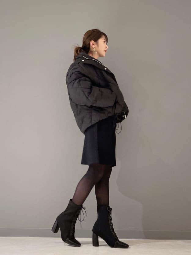 ブラック系のブルゾン、ブラック系のワンピース、ブラック系のブーツを着用したレディースの冬コーディネートの2枚目の写真