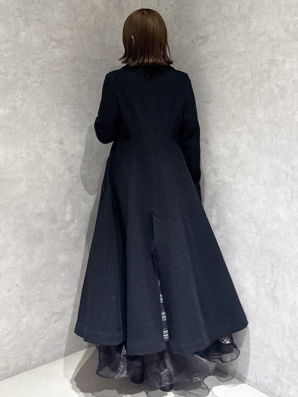 ブラック系のスカート、ブラック系のニット/セーター、ブラック系のその他アウターを着用したレディースの冬コーディネートの3枚目の写真