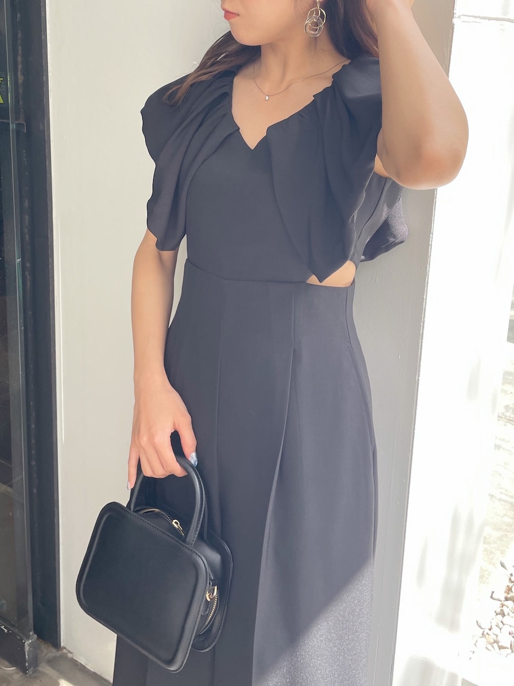 ブラック系のハンドバッグ、ブラック系のパンプス、ブラック系のつなぎ/オールインワンを着用したレディースの春コーディネートの5枚目の写真