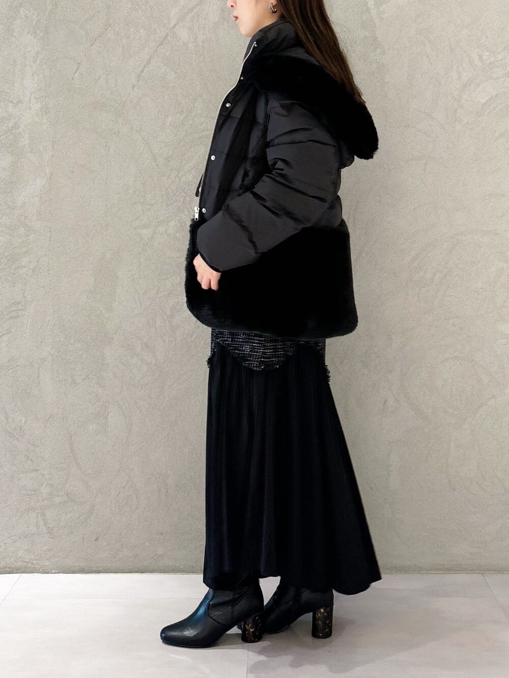 ブラック系のスカート、ブラック系のブーツ、ブラック系のショルダーバッグを着用したレディースの秋コーディネートの4枚目の写真