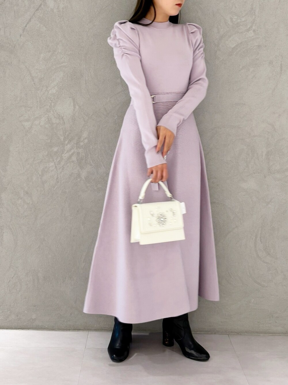 ホワイト系のショルダーバッグ、ブラック系のブーツ、パープル系のワンピースを着用したレディースの冬コーディネートの9枚目の写真