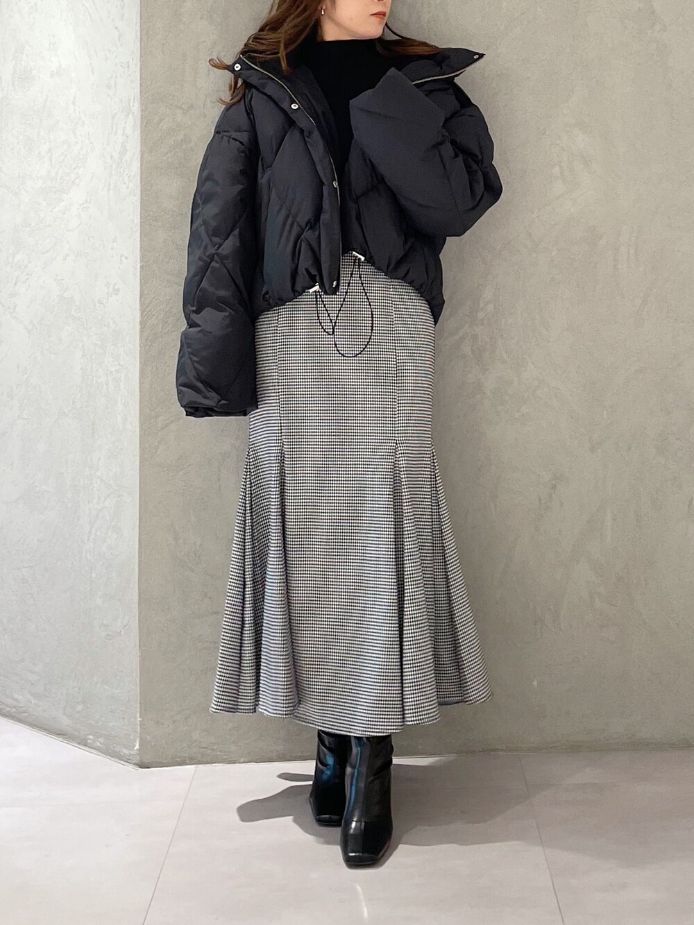 その他のスカート、ブラック系のブーツ、ブラック系のダウンジャケット/コートを着用したレディースの秋コーディネートの3枚目の写真