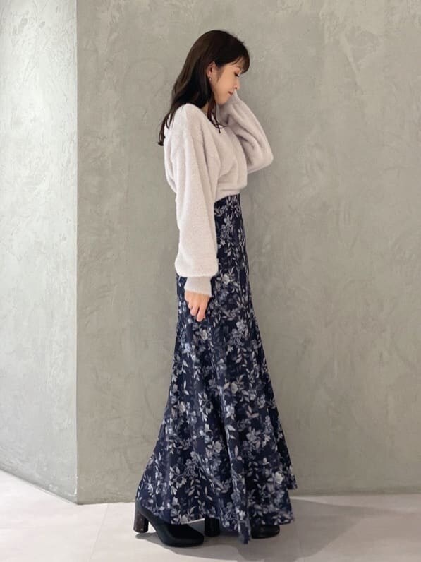 ピンク系のニット/セーター、ブルー系のスカートを着用したレディースの秋コーディネートの2枚目の写真