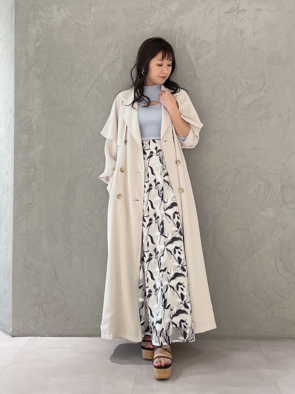 ホワイト系のスカート、ブルー系のニット/セーター、ホワイト系のトレンチコートを着用したレディースの春コーディネートの7枚目の写真