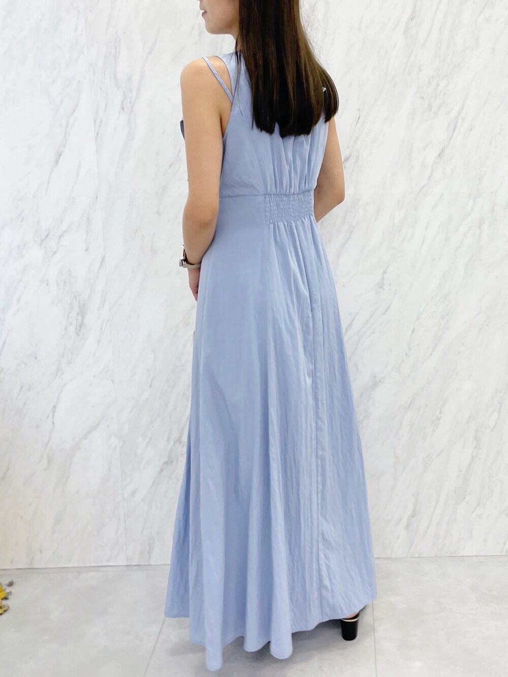 ブルー系のワンピース、ブラック系のサンダル、ホワイト系のハンドバッグを着用したレディースの夏コーディネートの4枚目の写真