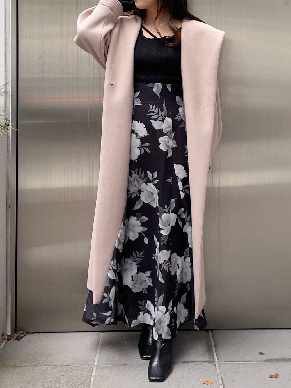 ブラック系のスカート、ブラック系のニット/セーター、ベージュ系のチェスターコートを着用したレディースの秋コーディネートの6枚目の写真