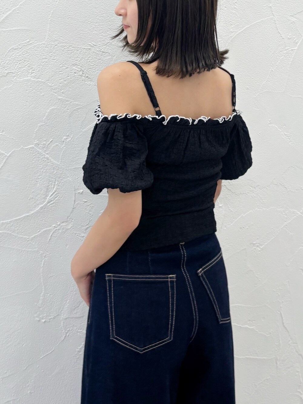 ブルー系のデニムパンツ、ホワイト系のサンダル、ブラック系のTシャツ/カットソーを着用したレディースの夏コーディネートの6枚目の写真