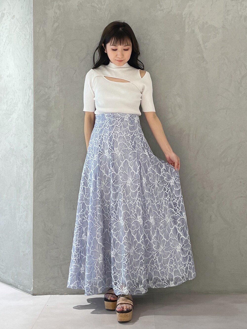 ブルー系のスカート、ブラック系のサンダル、ホワイト系のニット/セーターを着用したレディースの春コーディネートの4枚目の写真