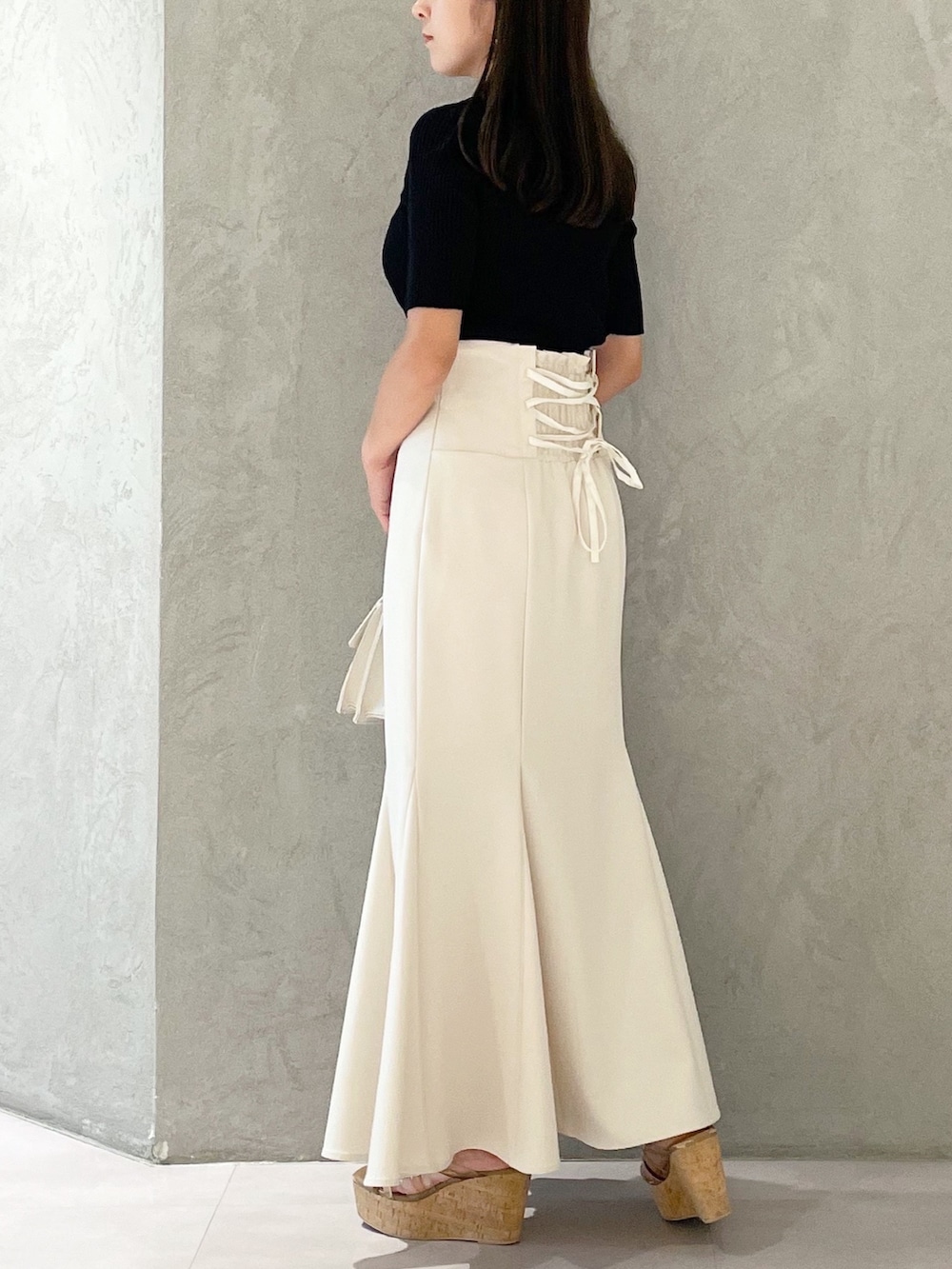 ピンク系のスカート、ブラウン系のサンダル、ベージュ系のショルダーバッグを着用したレディースの夏コーディネートの4枚目の写真