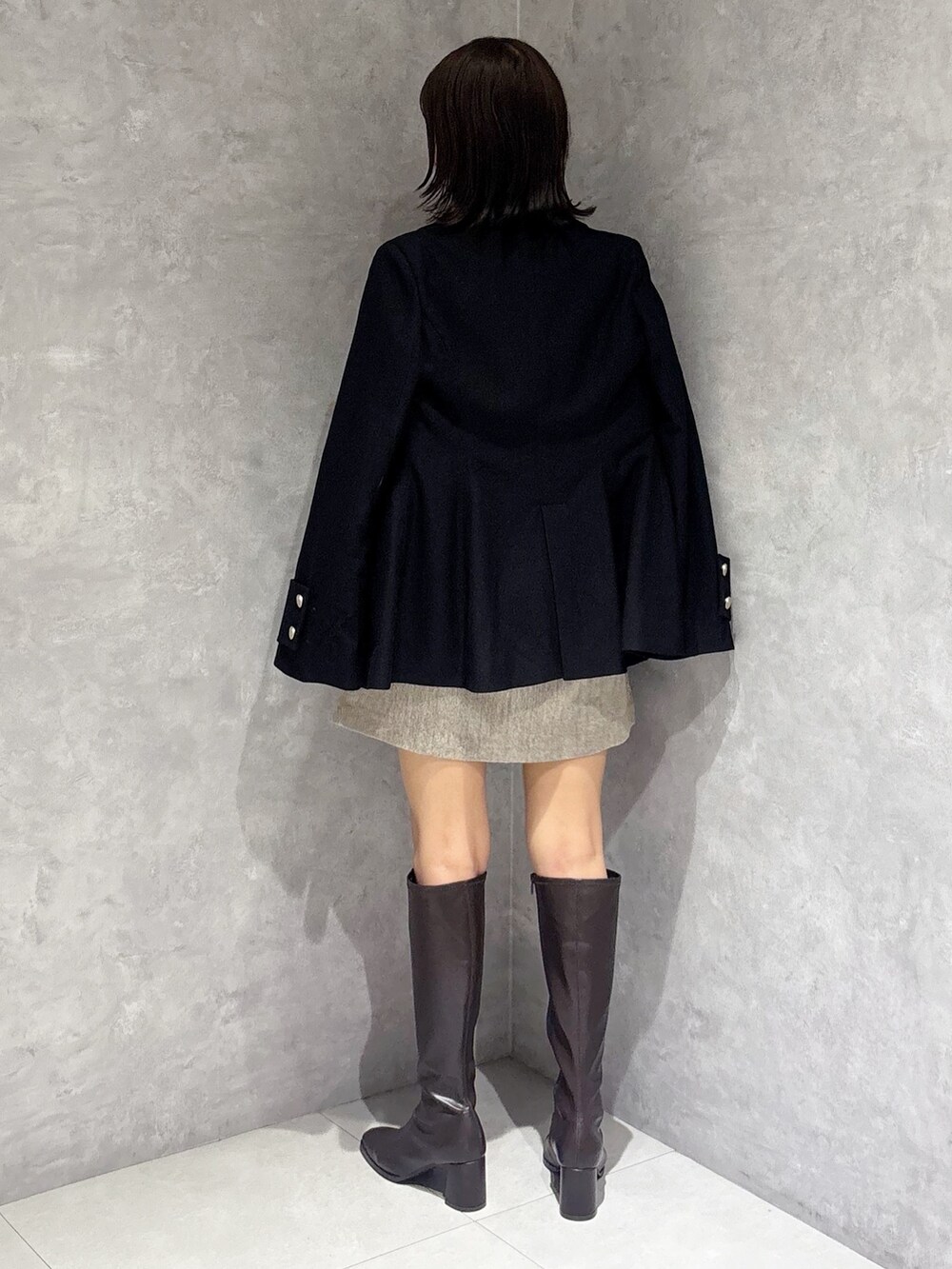 ブラウン系のワンピース、ブラウン系のブーツ、ブラック系のハンドバッグを着用したレディースの秋コーディネートの3枚目の写真