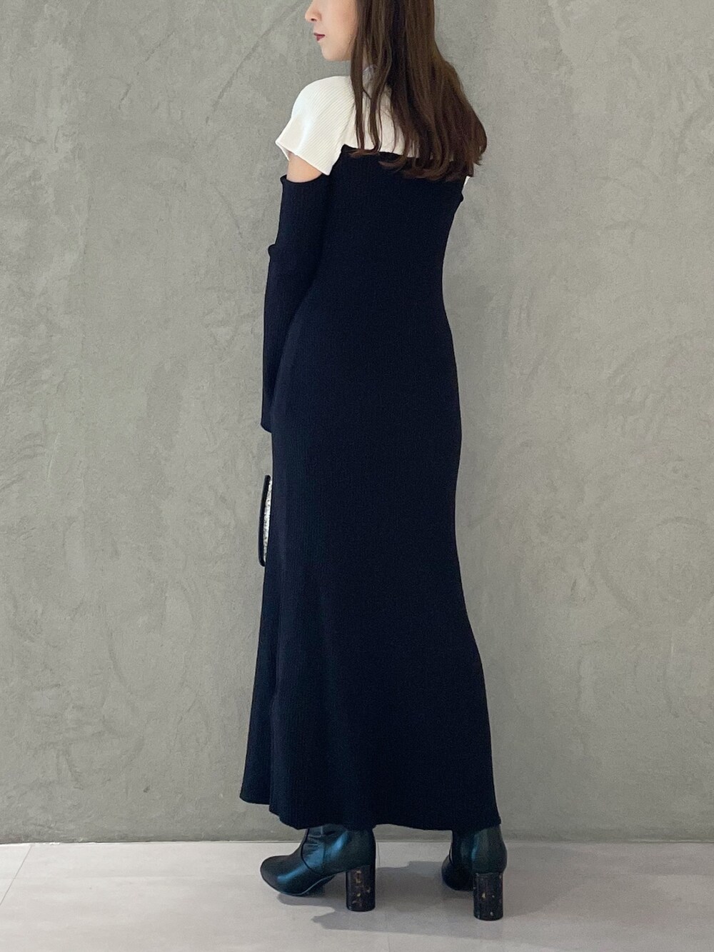 ブラック系のワンピース、ブラック系のショルダーバッグ、ブラック系のブーツを着用したレディースの秋コーディネートの5枚目の写真