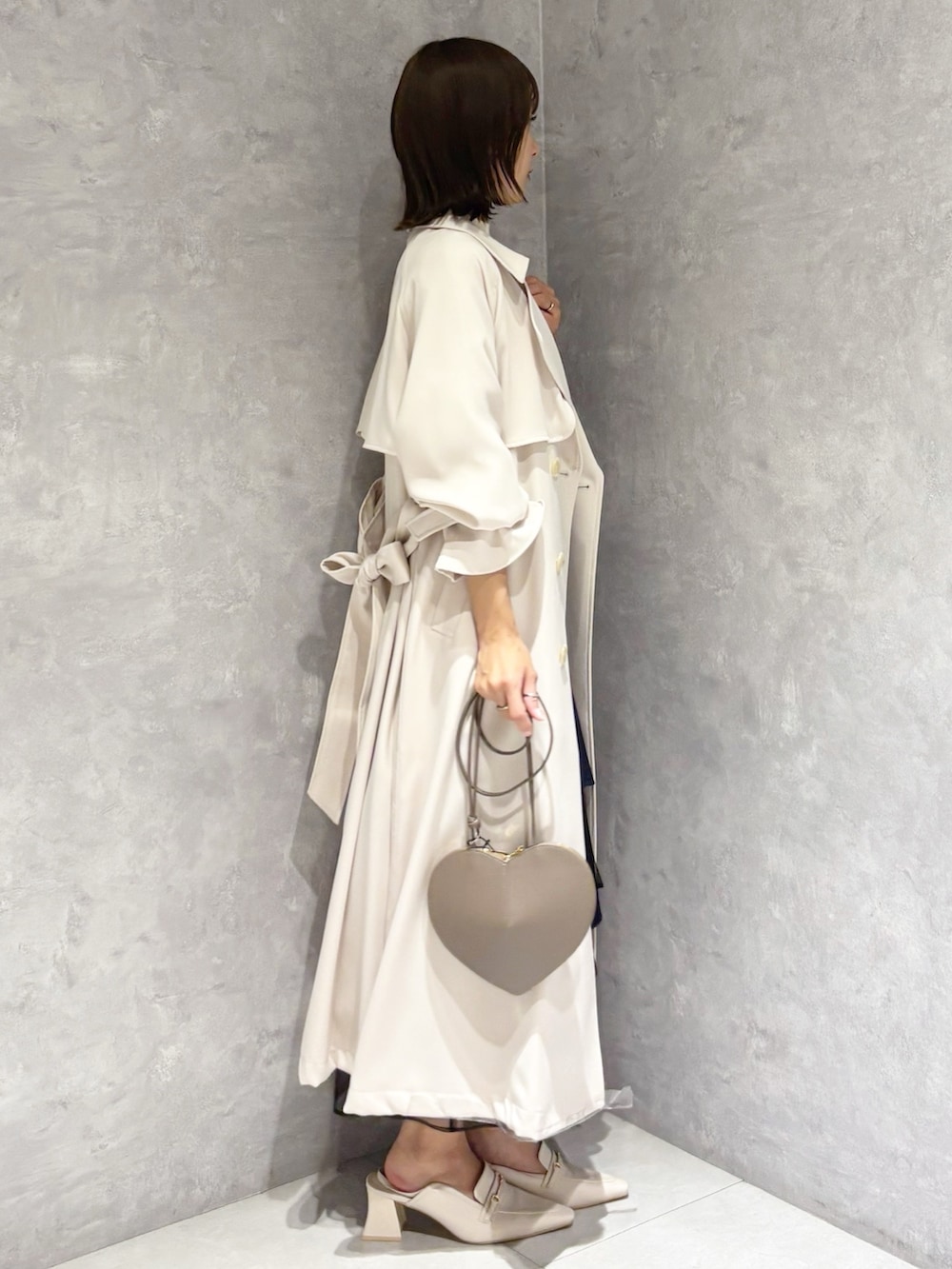 ブルー系のスカート、ホワイト系のニット/セーター、ホワイト系のパンプスを着用したレディースの春コーディネートの4枚目の写真