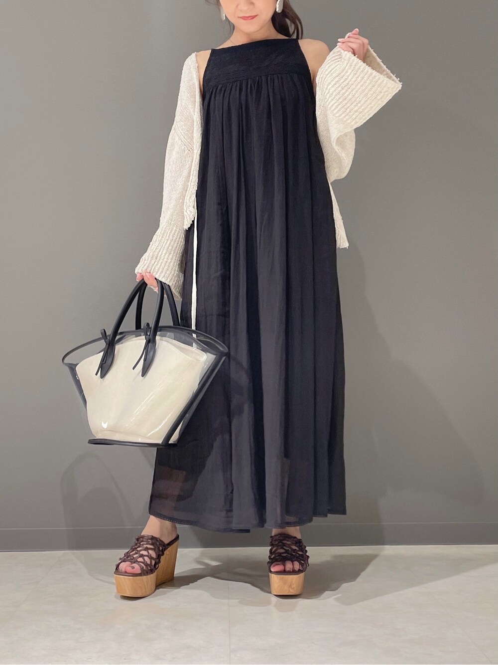 ブラック系のトートバッグ、ブラック系のワンピース、ブラウン系のサンダルを着用したレディースの春コーディネートの2枚目の写真