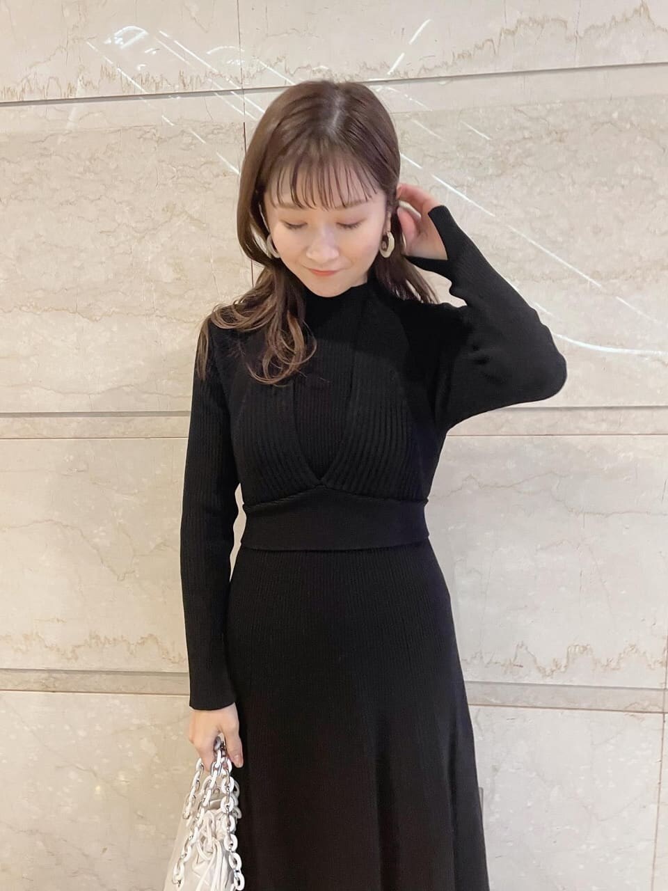 ブラック系のワンピース、ブラック系のその他シューズ、イエロー系のショルダーバッグを着用したレディースの冬コーディネートの2枚目の写真