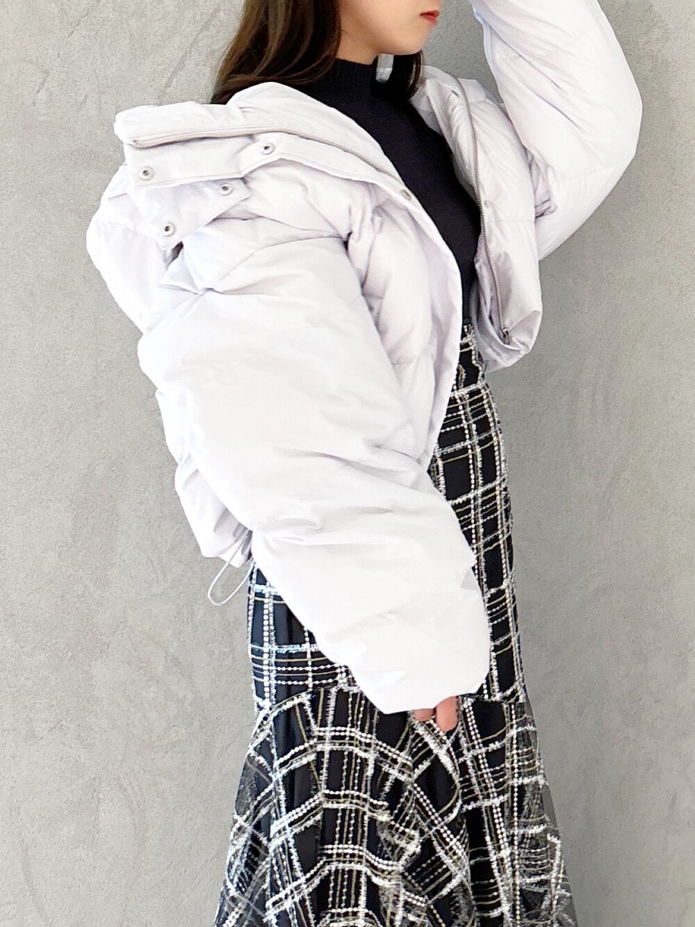 ブラック系のスカート、ブラック系のブーツ、グレー系のニット/セーターを着用したレディースの秋コーディネートの4枚目の写真