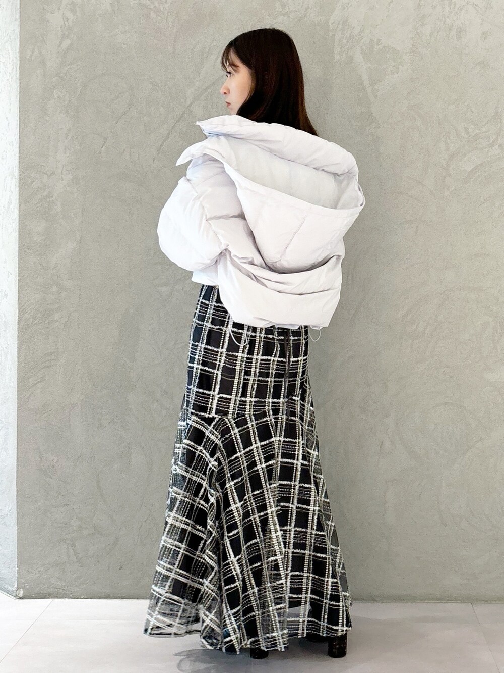 ブラック系のスカート、ブラック系のブーツ、グレー系のニット/セーターを着用したレディースの秋コーディネートの2枚目の写真