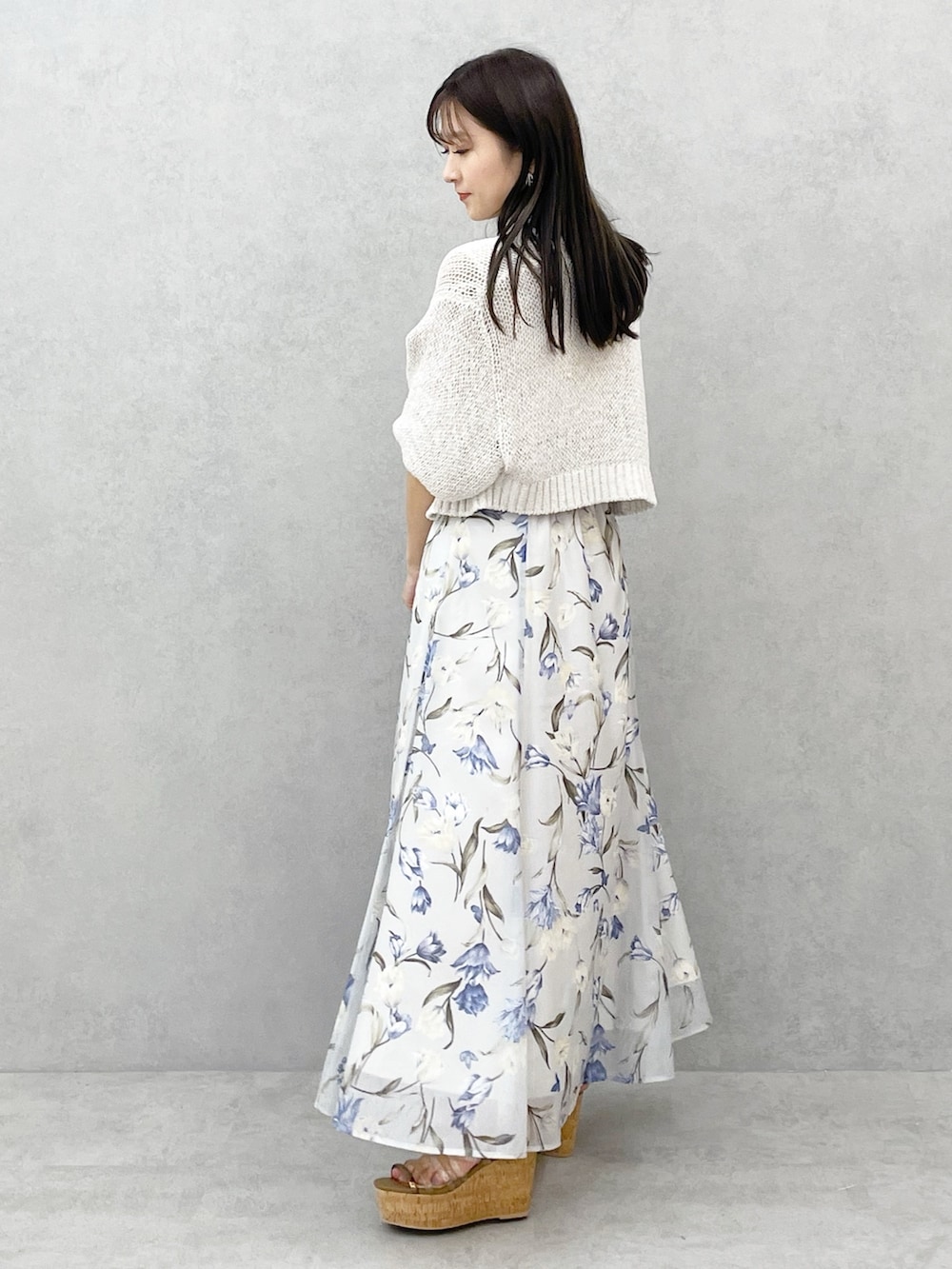 ブラウン系のサンダル、ブルー系のワンピース、ホワイト系のカーディガン/ボレロを着用したレディースの春コーディネートの2枚目の写真